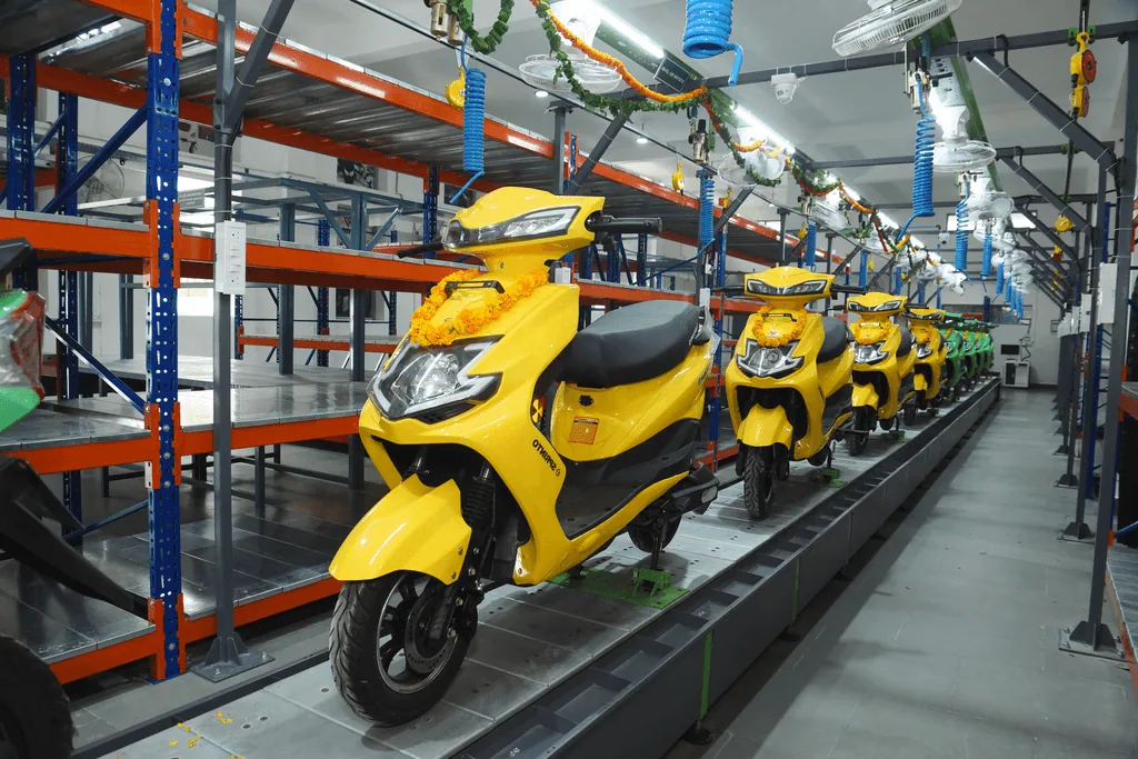 A fleet of yellow electric scooters at the factory