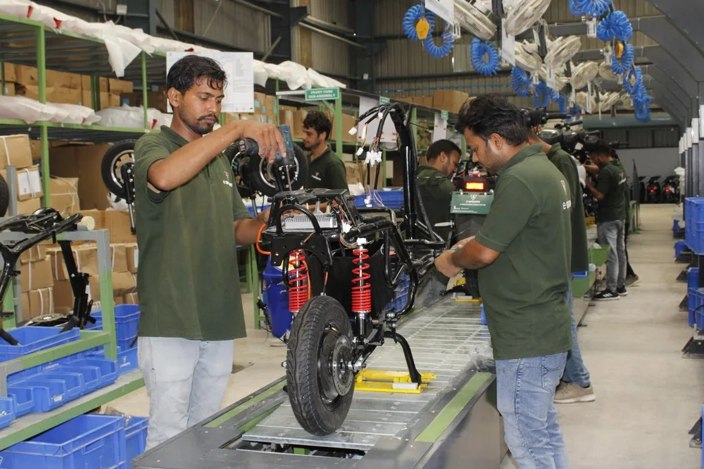 Engineers assembling and checking scooter parts